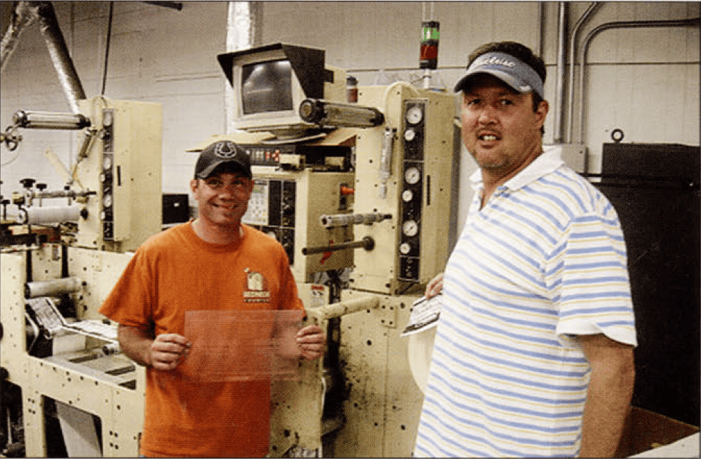 Kevin Hood (left) holds up an ExSpect digital plate from PRPflexo that he and Jay Jones (right) have used to improve Masco's print quality